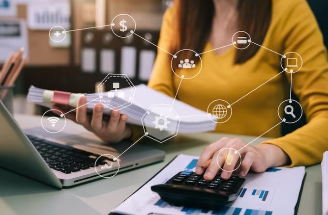 Mulher sentada em mesa com computador e calculadora fazendo gerenciamento de custos