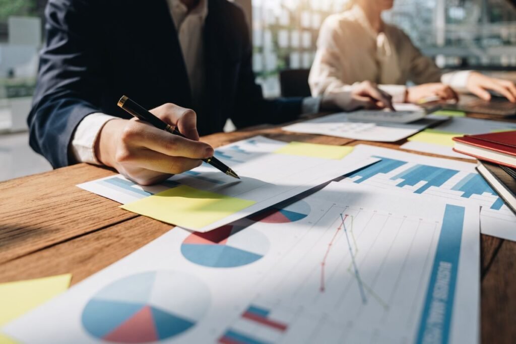 Duas pessoas analisando papéis sobre uma mesa, referentes à sua strategic sourcing.